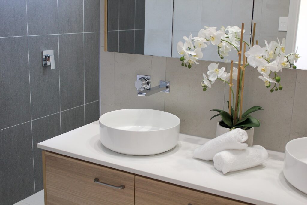 Modern bathroom interior design with orchid plant between the circular sinks