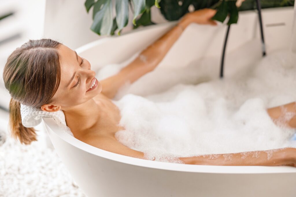 Lovely young woman enjoying bath foam while relaxing in the bathtub at home, Aromatherapy for Relaxation