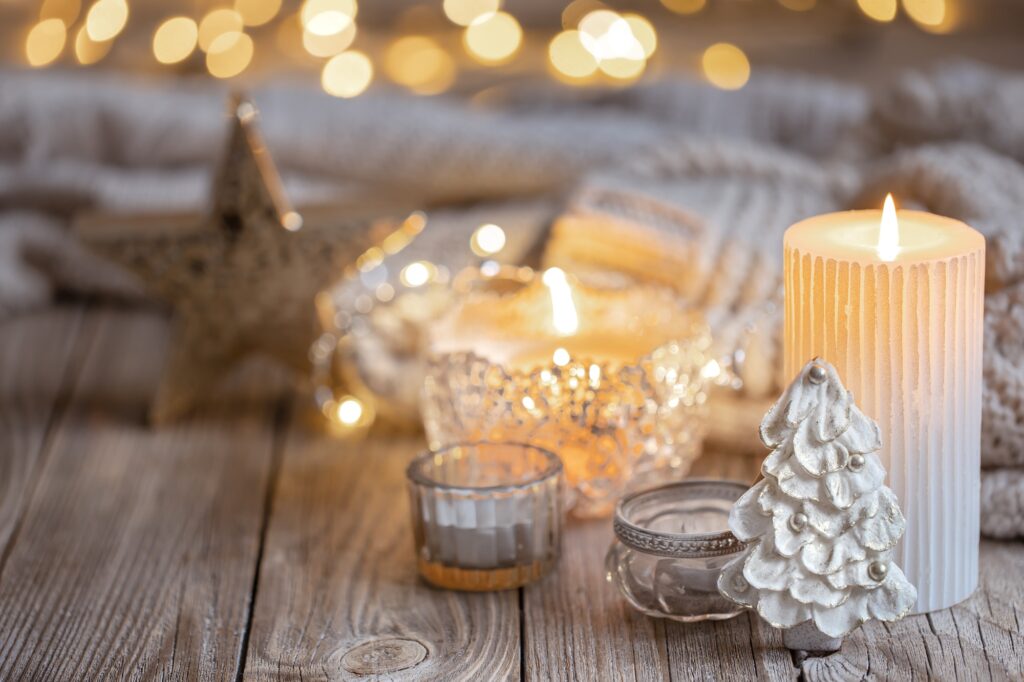 Christmas background with burning candle and decor details.