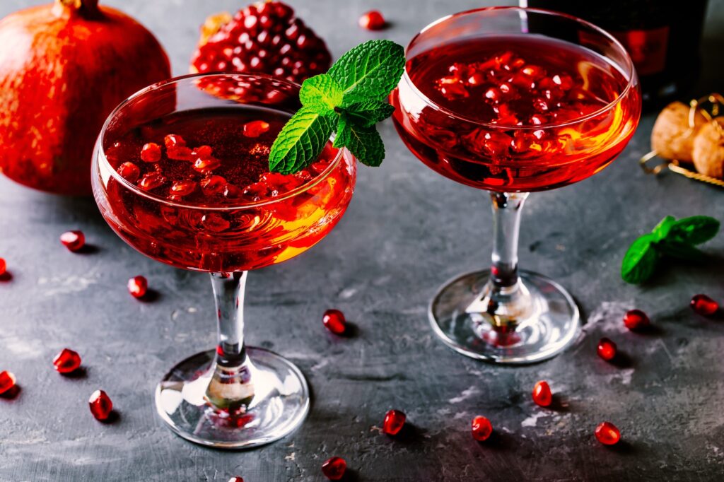 red cocktail with champagne and pomegranate seeds