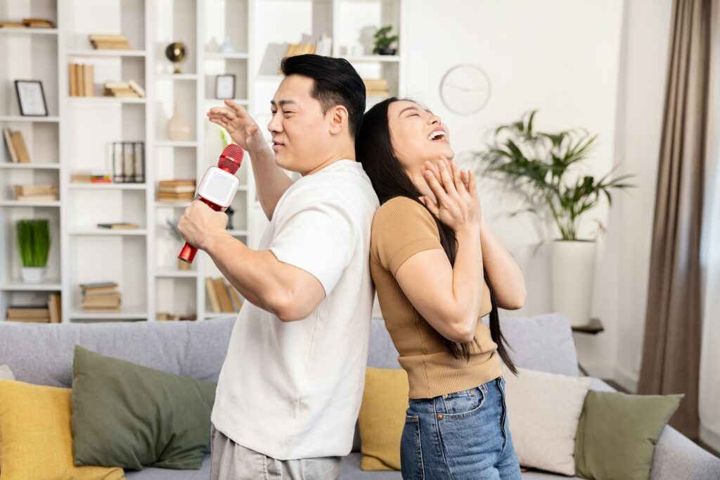 Happy Asian Couple Enjoying Dance and Karaoke at Home Date Night Ideas for COuples