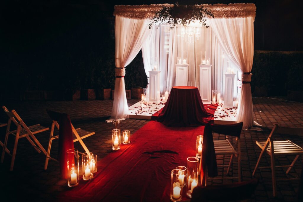 wedding venue aisle with candles in glass lanterns and arch