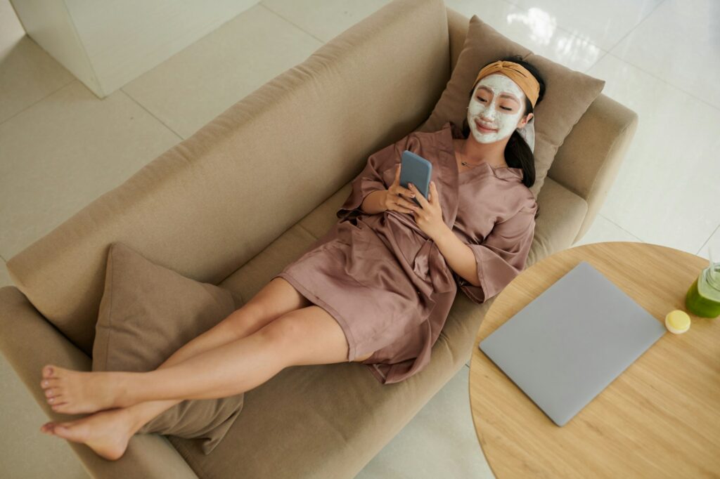 Woman Relaxing on Couch with Face Mask on DIY Facial at home