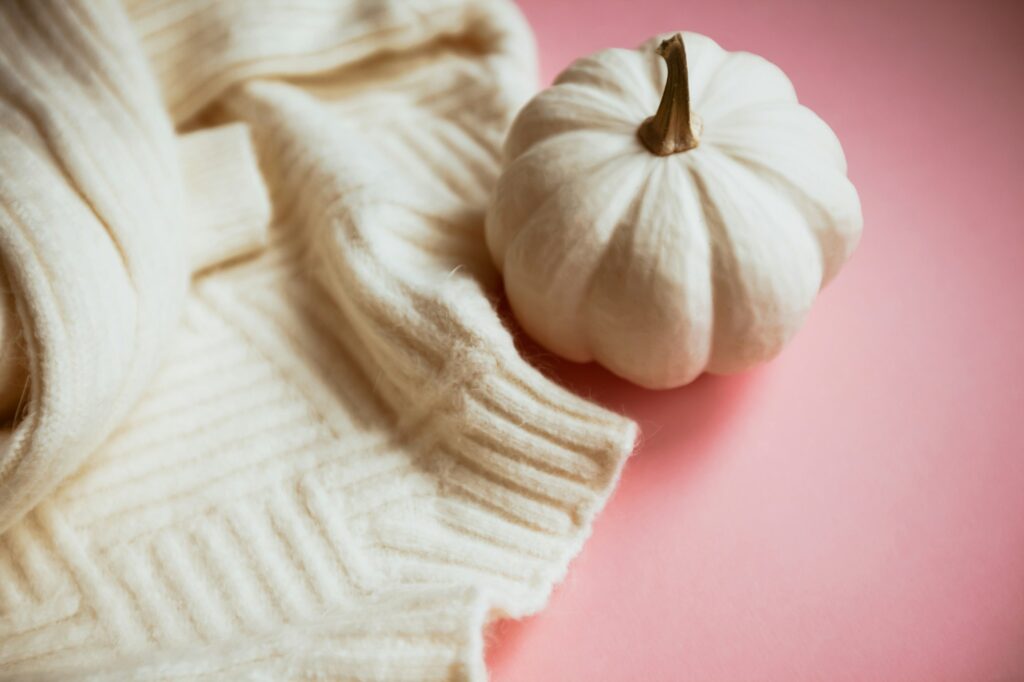 Fall composition with white sweater and pumpkin Cozy Fall Rituals