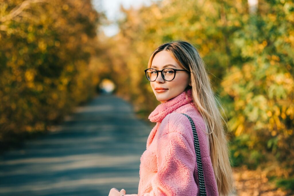 Portrait of attractive caucasian woman walking in a autumn park. Cozy Fall Rituals